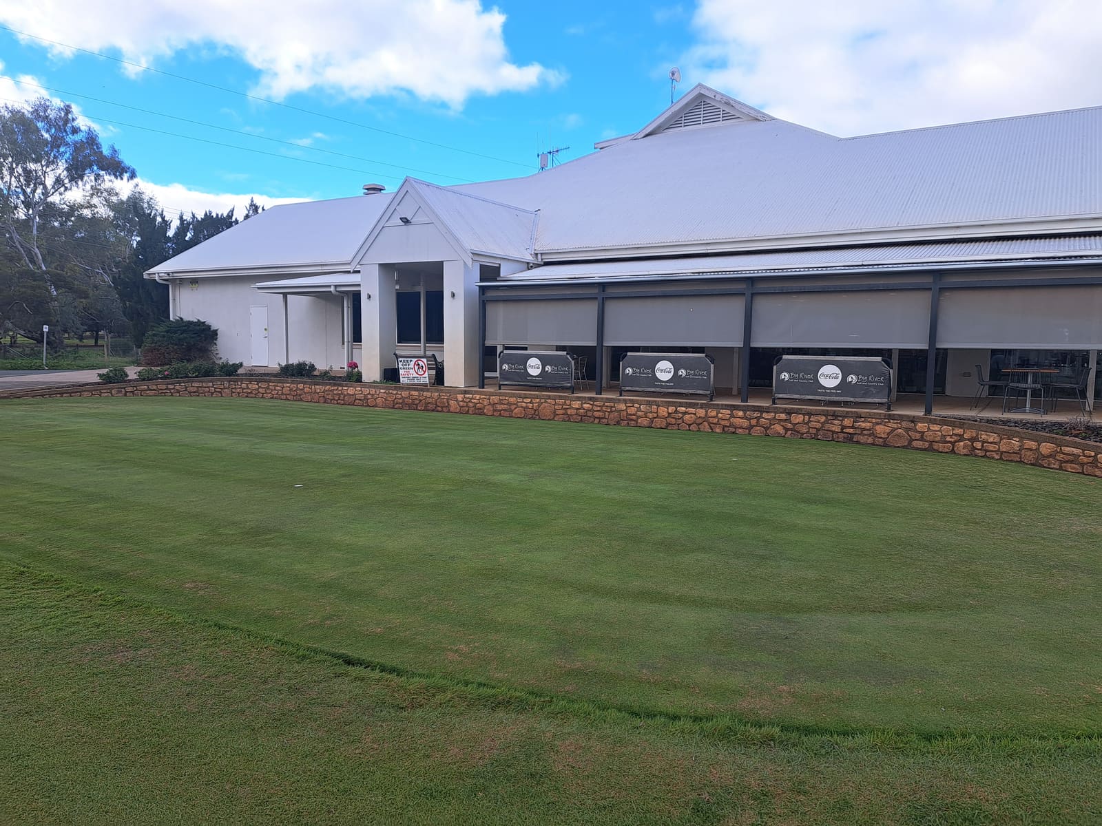 Regional Australian golf clubhouse beside a manicured green lawn