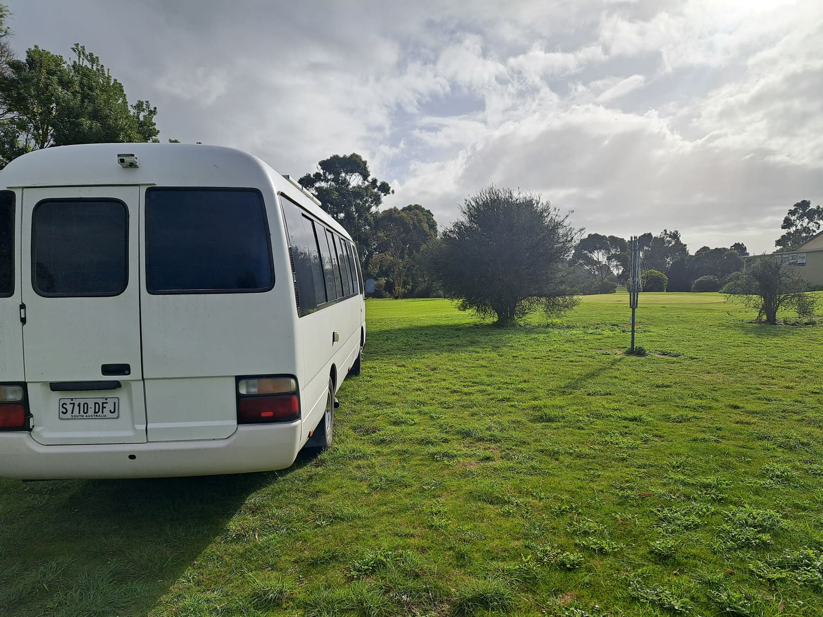 Campervan parked on grass near an Australian golf course stay area